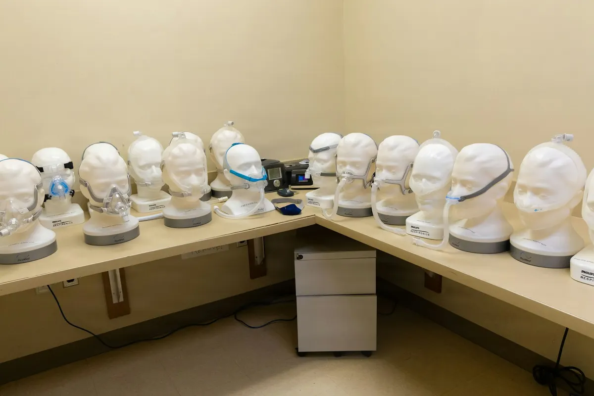 A row of CPAP masks displayed on mannequin heads in a sleep clinic