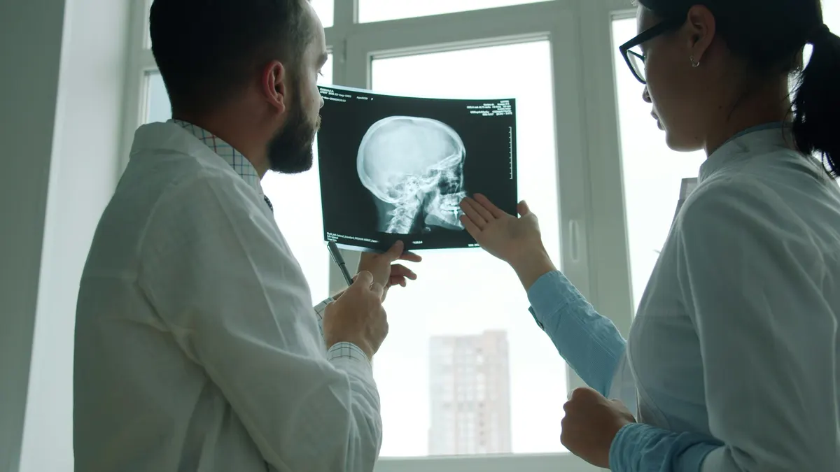 Two doctors reviewing a lateral skull X-ray together