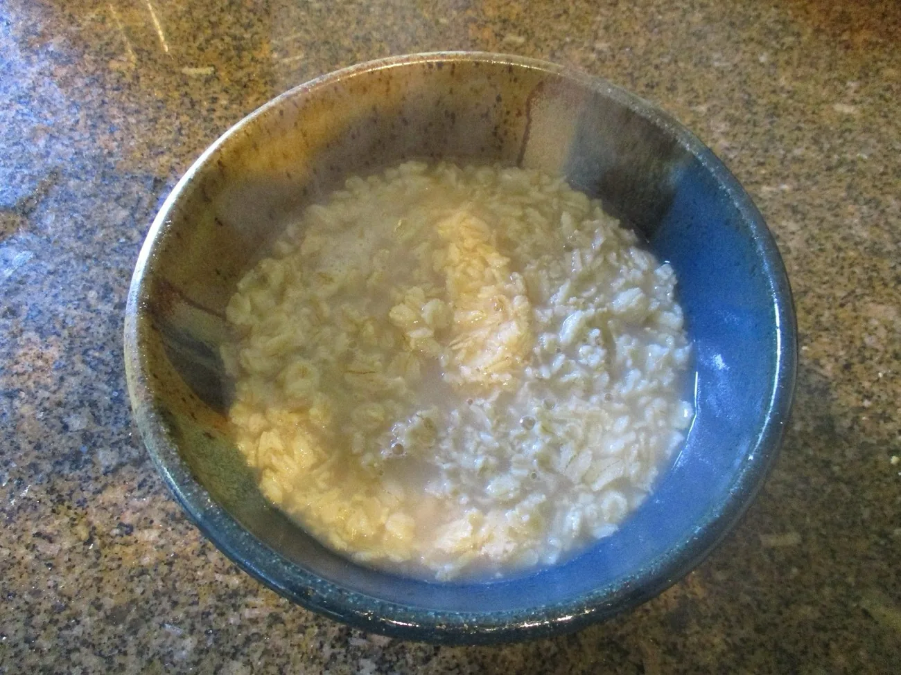 A warm bowl of cooked oatmeal porridge: a soft, protein-friendly breakfast during recovery